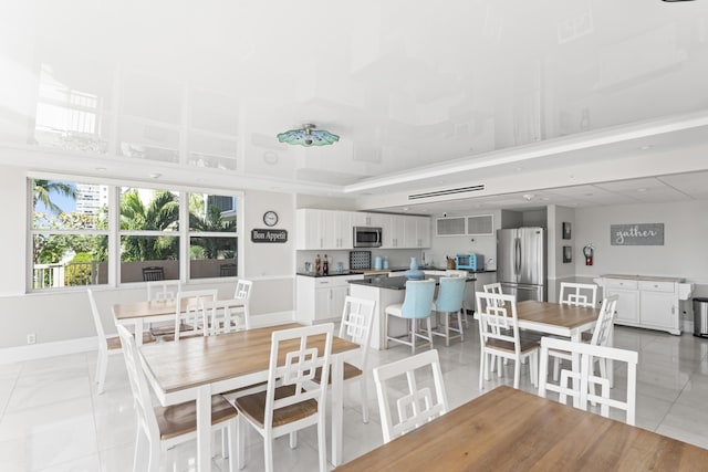 dining area with light tile patterned flooring and baseboards