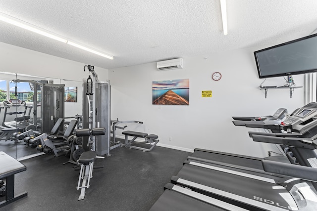 gym featuring a textured ceiling, a wall mounted AC, and baseboards