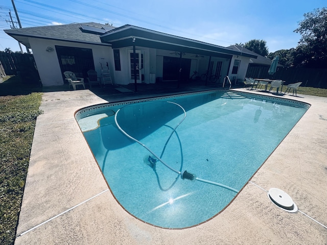 view of swimming pool with a fenced in pool, ceiling fan, fence, french doors, and a patio