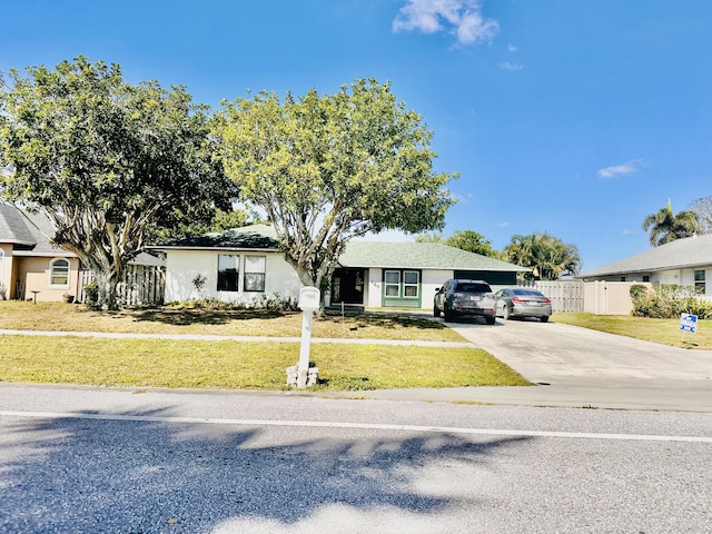 ranch-style home with stucco siding, driveway, a front lawn, and fence