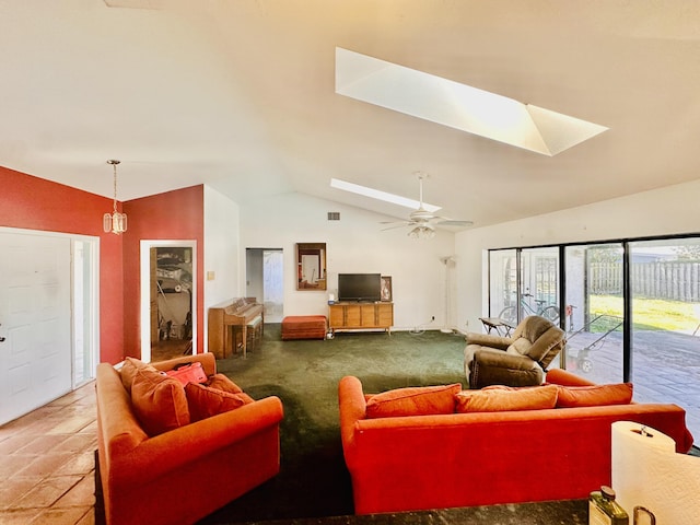 living room featuring vaulted ceiling with skylight and a ceiling fan