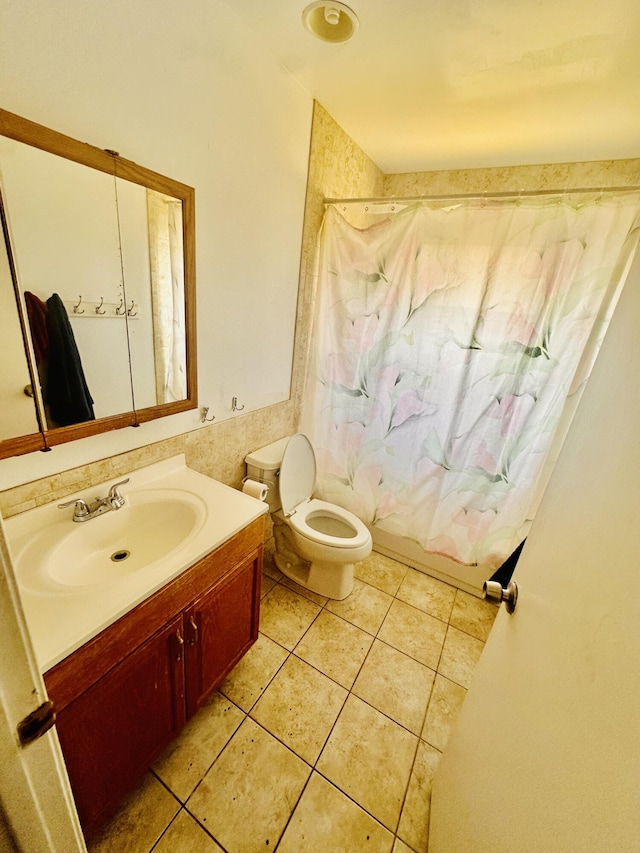 full bath featuring tile patterned floors, shower / bath combo with shower curtain, toilet, and vanity