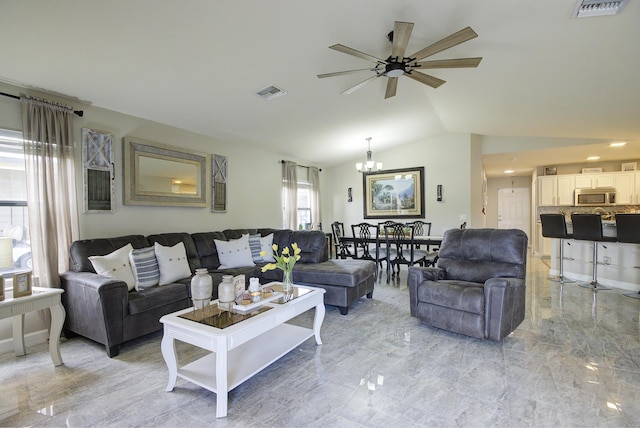 living area featuring lofted ceiling, visible vents, and marble finish floor