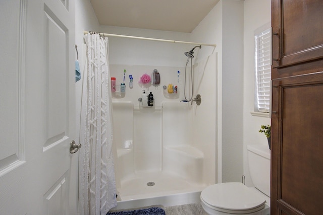 bathroom featuring curtained shower and toilet