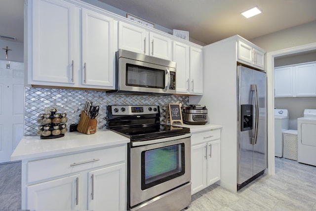 kitchen with light countertops, decorative backsplash, white cabinets, washer and dryer, and stainless steel appliances