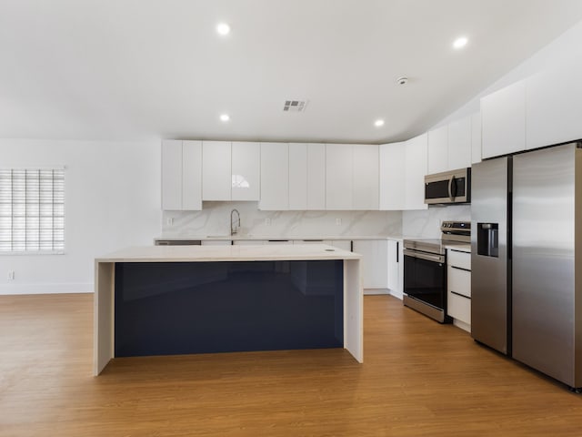 4524 Concordia Ln, Boynton Beach, FL 33436 - kitchen featuring appliances with stainless steel finishes, a center island, light wood finished floors, light countertops, and recessed lighting