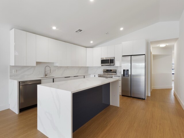 4524 Concordia Ln, Boynton Beach, FL 33436 - kitchen with stainless steel appliances, a kitchen island, light wood-style flooring, tasteful backsplash, and recessed lighting