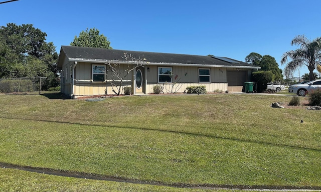 view of front facade with a front yard, fence, and a garage