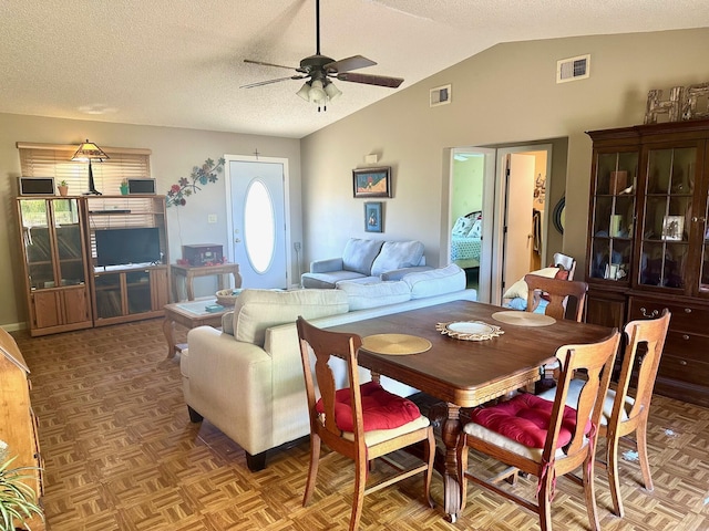 dining space with visible vents, lofted ceiling, a textured ceiling, and ceiling fan