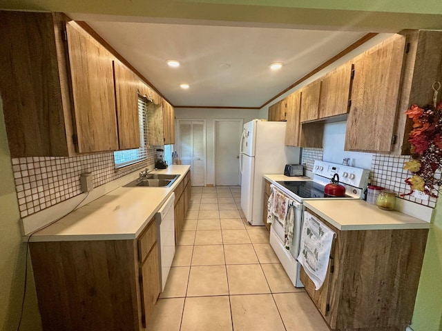 kitchen with a sink, white appliances, light tile patterned floors, and light countertops