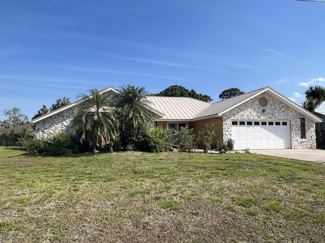 view of front facade with a garage, a front lawn, metal roof, and driveway