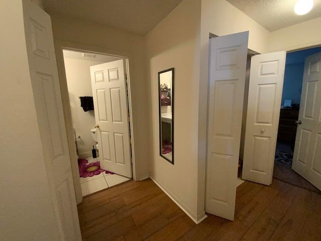 hall featuring baseboards and wood finished floors