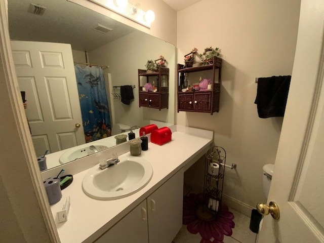 bathroom featuring visible vents, baseboards, toilet, a shower with shower curtain, and vanity