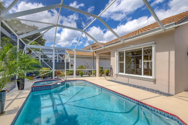 view of pool featuring a pool with connected hot tub, a lanai, and a patio area