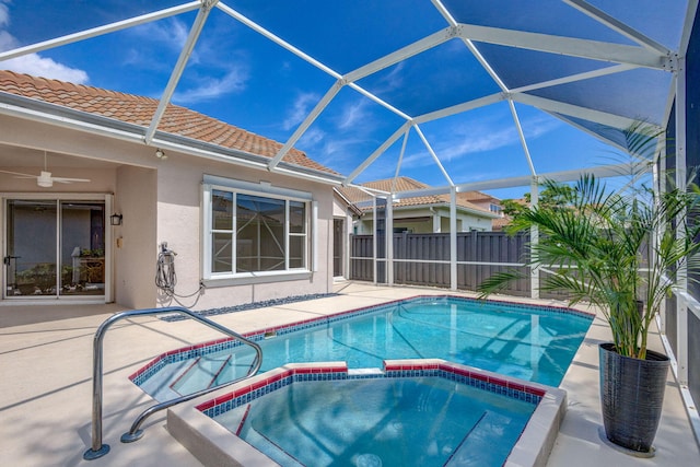 view of swimming pool featuring a ceiling fan, a pool with connected hot tub, a patio, fence, and a lanai