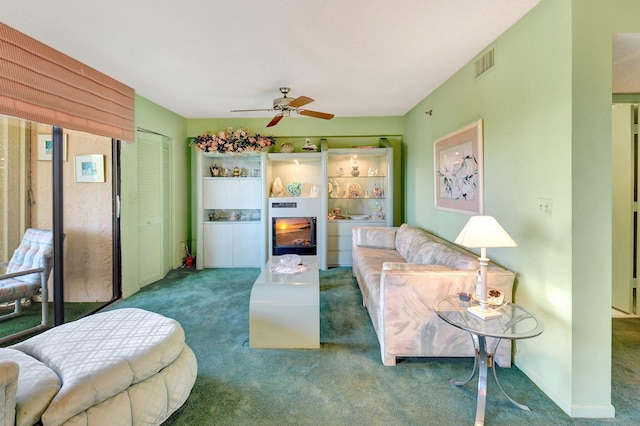 carpeted living area featuring a ceiling fan, visible vents, and baseboards