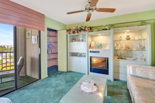 carpeted living area with a ceiling fan and a lit fireplace