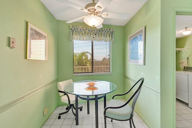 dining space with a textured ceiling, separate washer and dryer, baseboards, and ceiling fan