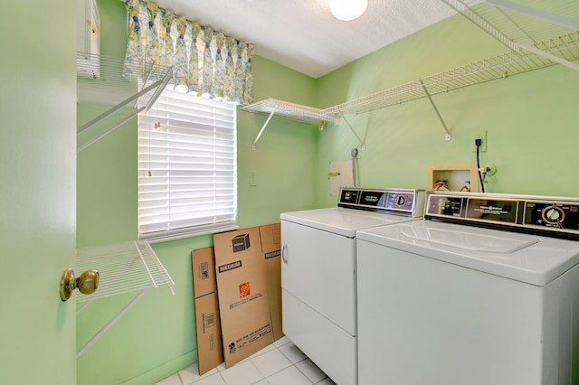 clothes washing area featuring laundry area, light tile patterned floors, and washing machine and dryer