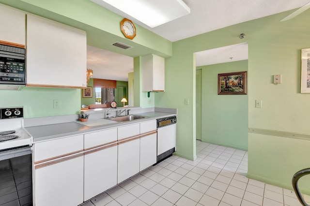 kitchen with visible vents, light countertops, white cabinets, white appliances, and a sink