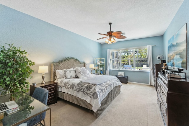 bedroom featuring light carpet, a textured ceiling, and ceiling fan