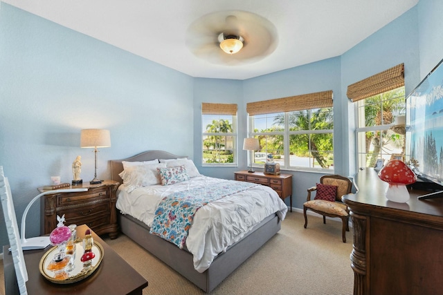 bedroom with ceiling fan, baseboards, and light carpet