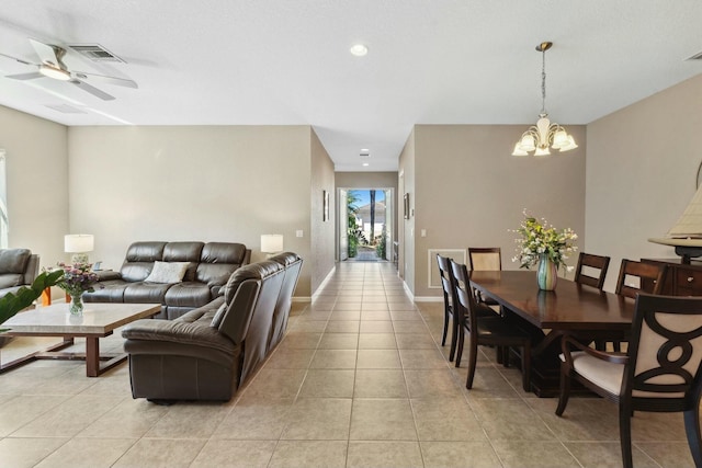 living room featuring light tile patterned flooring, visible vents, ceiling fan with notable chandelier, and baseboards