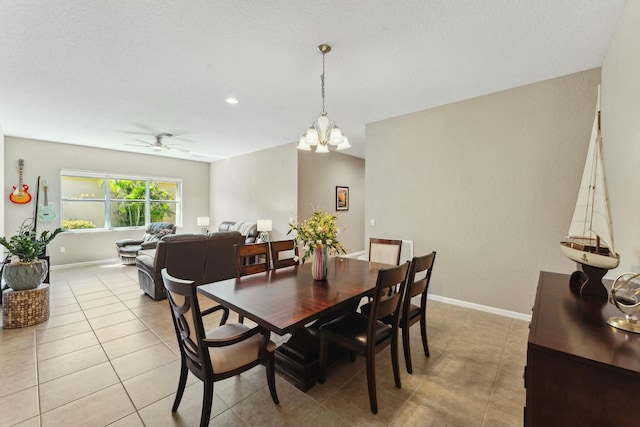 dining space with light tile patterned flooring, ceiling fan with notable chandelier, and baseboards