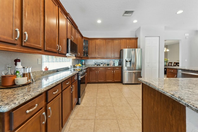 kitchen featuring light stone counters, light tile patterned floors, visible vents, and stainless steel appliances