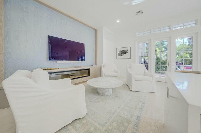 living room with visible vents, recessed lighting, and wood finished floors