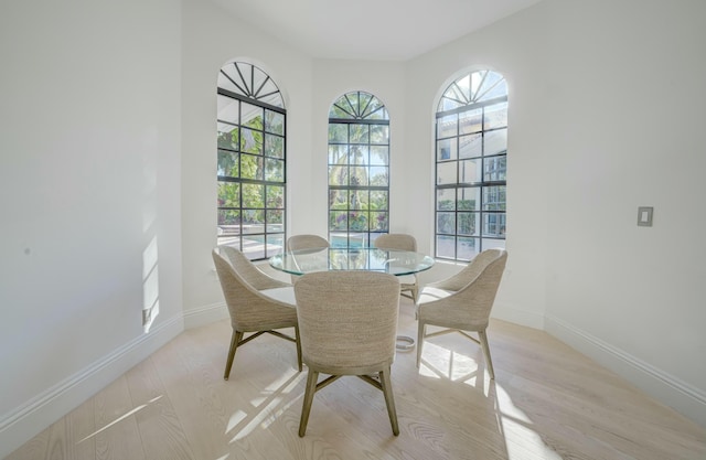 dining area with baseboards and light wood finished floors