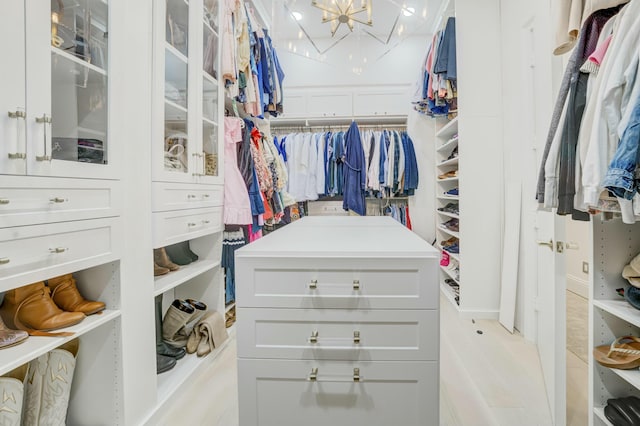 walk in closet featuring a notable chandelier