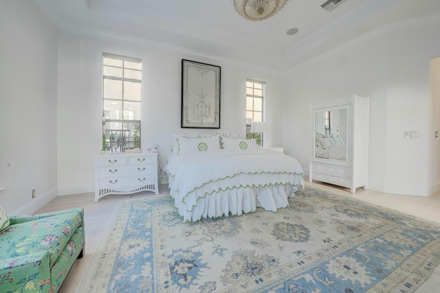 bedroom with baseboards, light wood finished floors, and ornamental molding