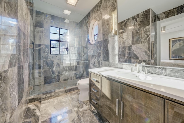 bathroom featuring vanity, a stall shower, tile walls, toilet, and marble finish floor