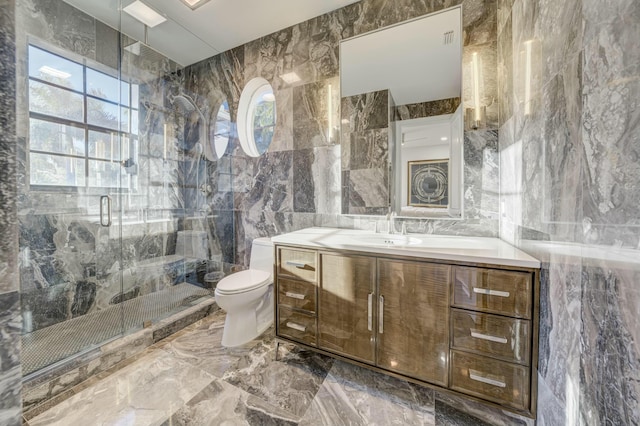 full bathroom with a shower stall, toilet, vanity, marble finish floor, and tile walls