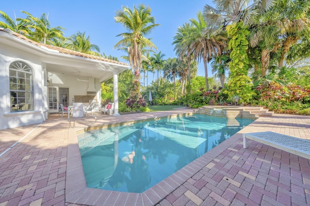 view of pool with a patio, a ceiling fan, and a pool with connected hot tub