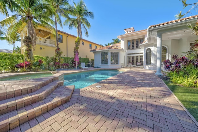 pool with french doors and a patio area