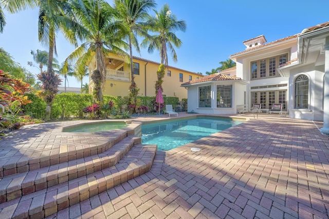 view of pool featuring french doors, a patio, and a pool with connected hot tub