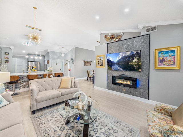 7882 Lake Sands Dr, Delray Beach, FL 33446 - living area featuring visible vents, a tiled fireplace, crown molding, and vaulted ceiling