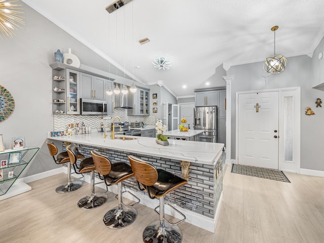 7882 Lake Sands Dr, Delray Beach, FL 33446 - kitchen featuring gray cabinets, a kitchen breakfast bar, appliances with stainless steel finishes, a peninsula, and crown molding