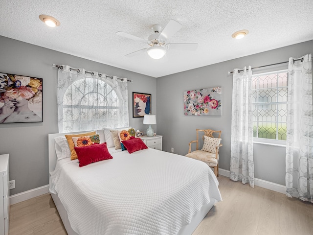 7882 Lake Sands Dr, Delray Beach, FL 33446 - bedroom with a textured ceiling, light wood-style flooring, baseboards, and ceiling fan