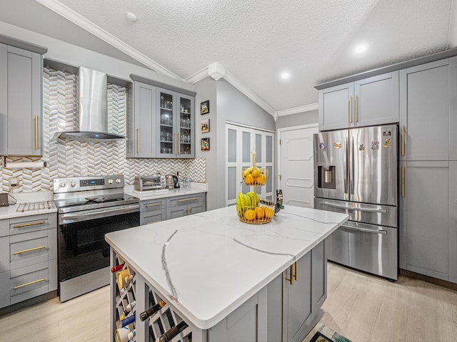 7882 Lake Sands Dr, Delray Beach, FL 33446 - kitchen featuring gray cabinetry, crown molding, decorative backsplash, stainless steel appliances, and wall chimney exhaust hood