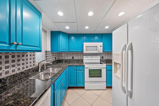 kitchen with blue cabinets, a sink, white appliances, light tile patterned floors, and decorative backsplash