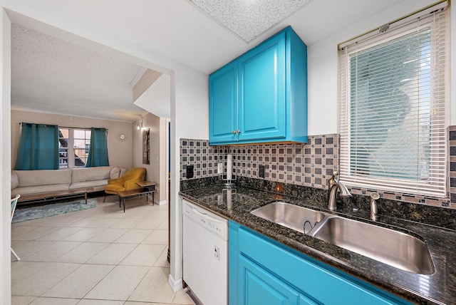 kitchen featuring light tile patterned floors, white dishwasher, a sink, tasteful backsplash, and open floor plan