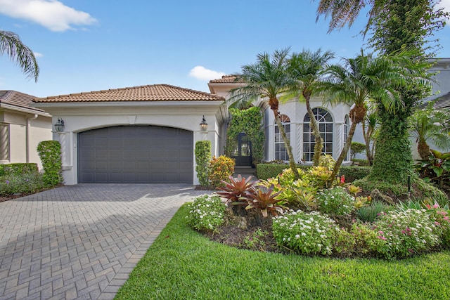 10255 Sand Cay Ln, West Palm Beach, FL 33412 - mediterranean / spanish house featuring an attached garage, stucco siding, decorative driveway, and a tile roof
