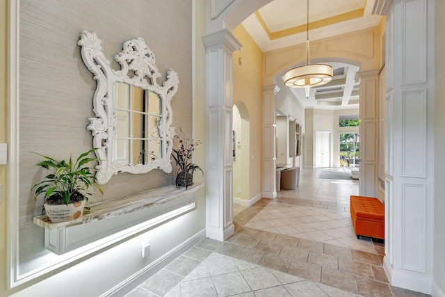 hall with baseboards, coffered ceiling, decorative columns, arched walkways, and ornamental molding