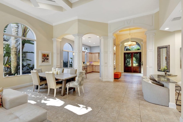 10255 Sand Cay Ln, West Palm Beach, FL 33412 - dining area with ornate columns, crown molding, arched walkways, light tile patterned floors, and a towering ceiling