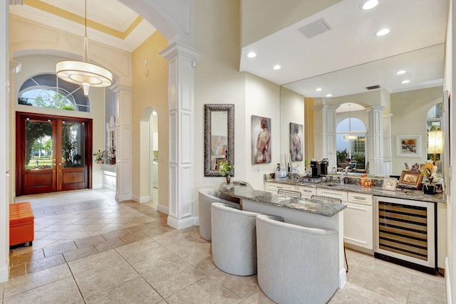 bar with visible vents, ornamental molding, recessed lighting, wine cooler, and ornate columns