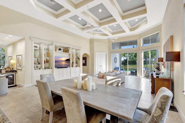 dining space with a high ceiling, a ceiling fan, beamed ceiling, and coffered ceiling