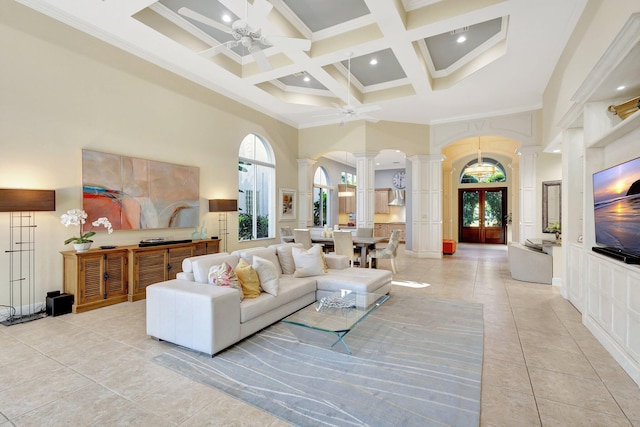 living area with a ceiling fan, french doors, arched walkways, a high ceiling, and decorative columns